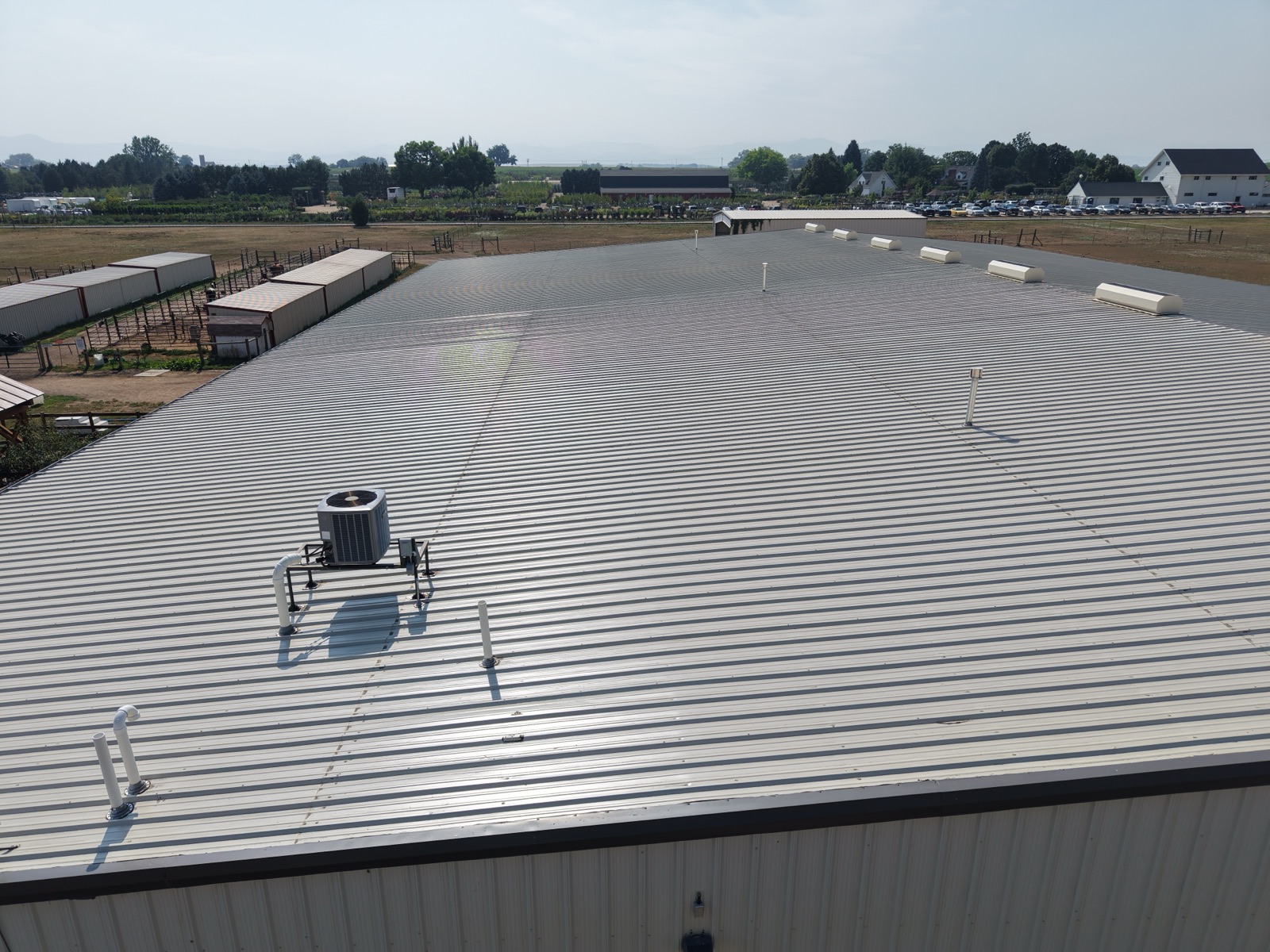 Aerial survey of a metal roof showing HVAC unit and roof vents