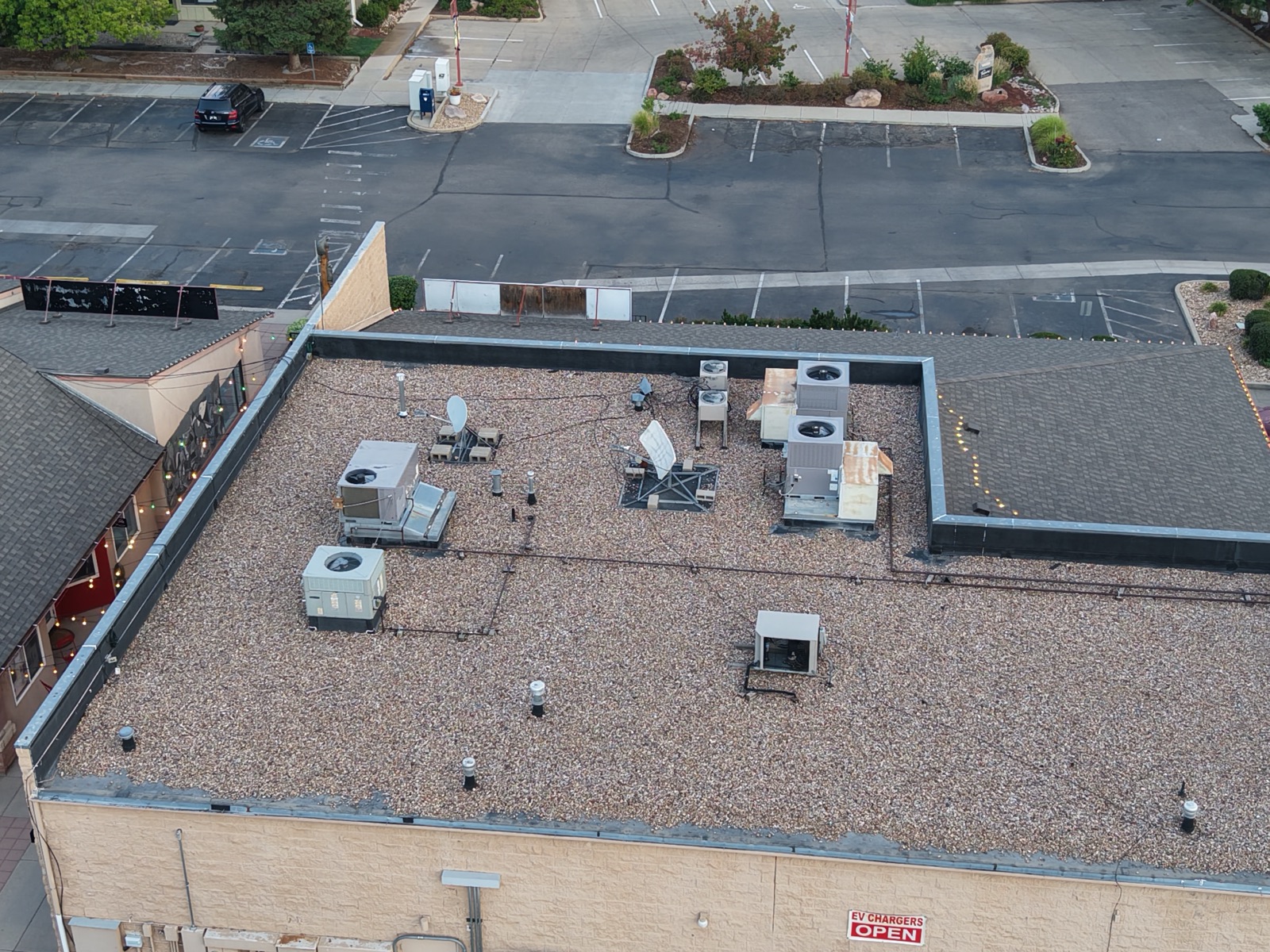 Aerial survey of a flat commercial roof with HVAC units and satellite dishes