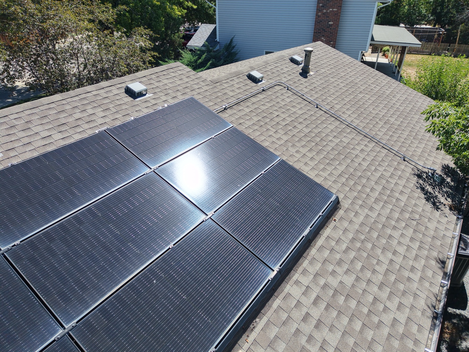 Close-up aerial survey of rooftop solar panels and roof vents